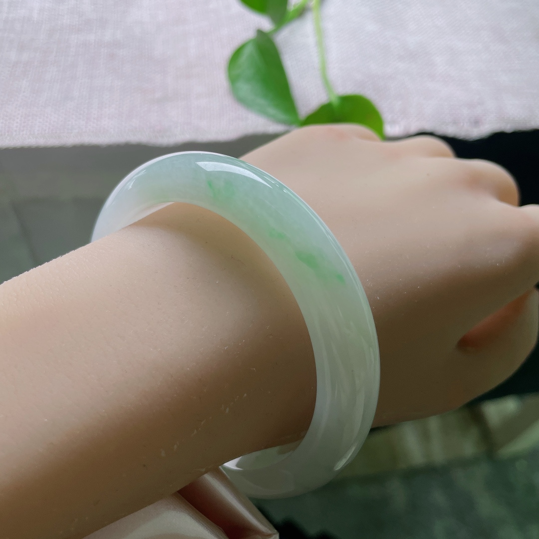 56.8/11.3/7.9，飘绿正圈，无裂，冰底清透如玉，一抹浅翠静落镯底，似远山浮于薄雾之间，清素柔和，自带静谧空灵的气韵。ss56943a