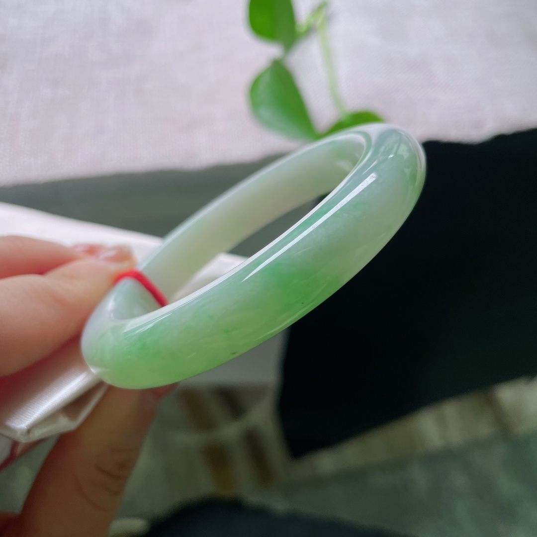 绿底正圈，无裂，冰底凝霜，一抹鲜活翠色漫染镯身，如玉湖之中漾开碧色春光，清透灵动，满目清新雅致。ss56956a