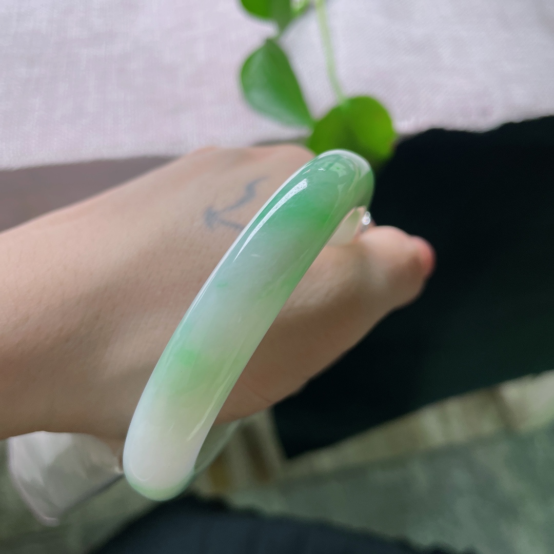 绿底正圈，无裂，冰底凝霜，一抹鲜活翠色漫染镯身，如玉湖之中漾开碧色春光，清透灵动，满目清新雅致。ss56956a