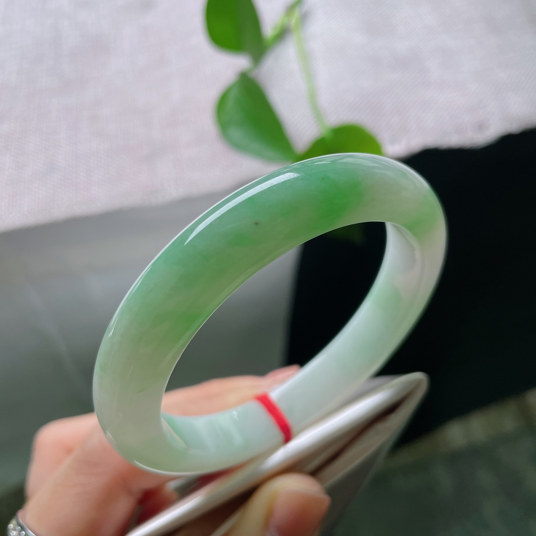 绿底正圈，无裂，冰底凝霜，一抹鲜活翠色漫染镯身，如玉湖之中漾开碧色春光，清透灵动，满目清新雅致。ss56956a