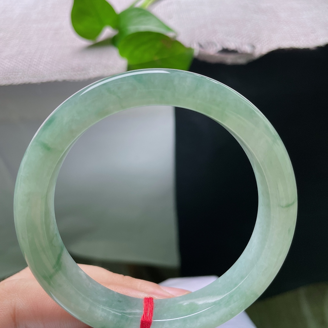 57.7/11.5/9，飘花正圈，底色是清润的湖水浅绿，通透温润，缕缕绿飘花随性萦绕镯身，自带清幽雅致的气韵，ss55853a