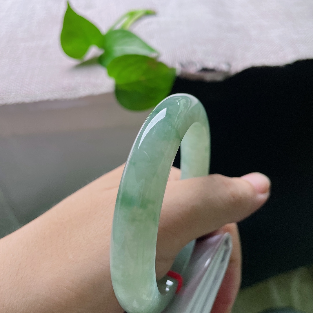 57.7/11.5/9，飘花正圈，底色是清润的湖水浅绿，通透温润，缕缕绿飘花随性萦绕镯身，自带清幽雅致的气韵，ss55853a