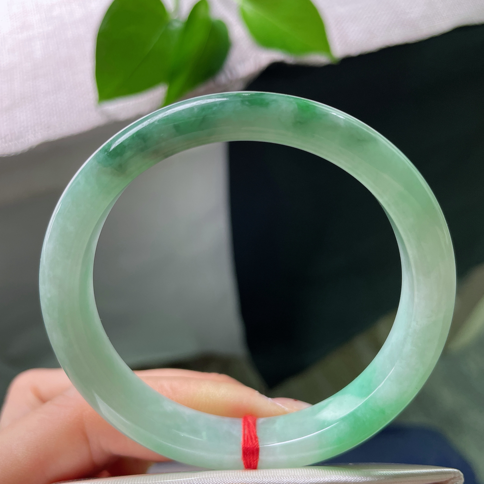 55.2/9.9/8.2，飘花正圈，皮纹，底色清甜柔和，一侧晕开一抹鲜亮阳绿，底端浓黑的飘花沉静内敛