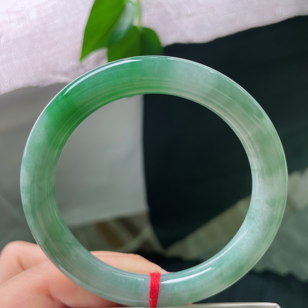 55.4/9.2，飘绿圆条，一点内纹，圆条镯型敦实雅致，绿水氤氲镯身，水光内敛，把一池远山碧色，戴于