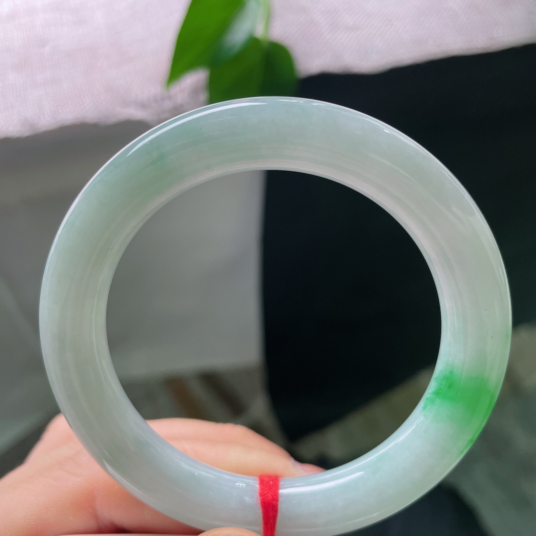 53.1/10，飘绿圆条，一点皮纹，一抹鲜翠悄然落于镯身，翠色灵动鲜活，如春风拂过山间碧潭，清逸温婉。ss56713a