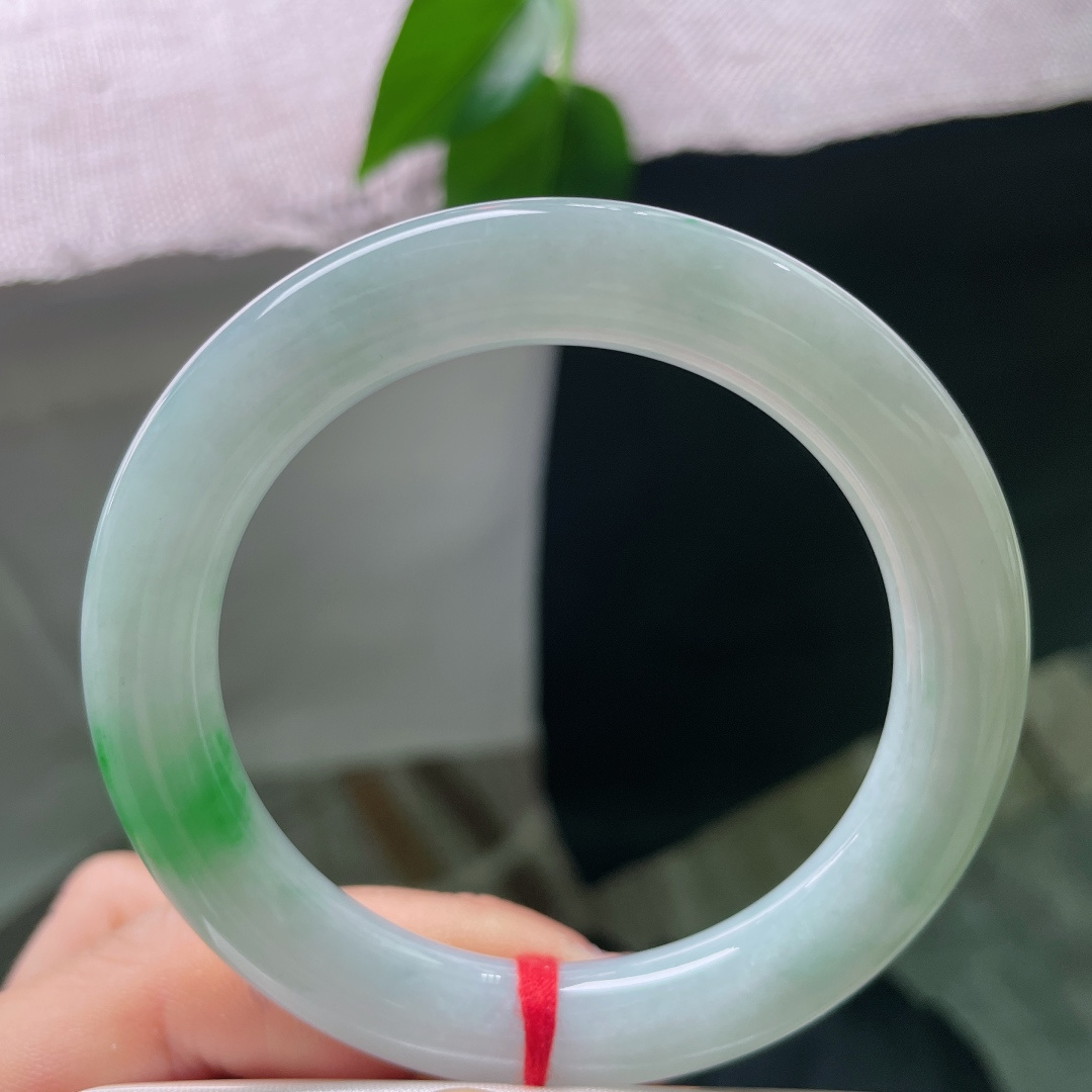 53.1/10，飘绿圆条，一点皮纹，一抹鲜翠悄然落于镯身，翠色灵动鲜活，如春风拂过山间碧潭，清逸温婉。ss56713a
