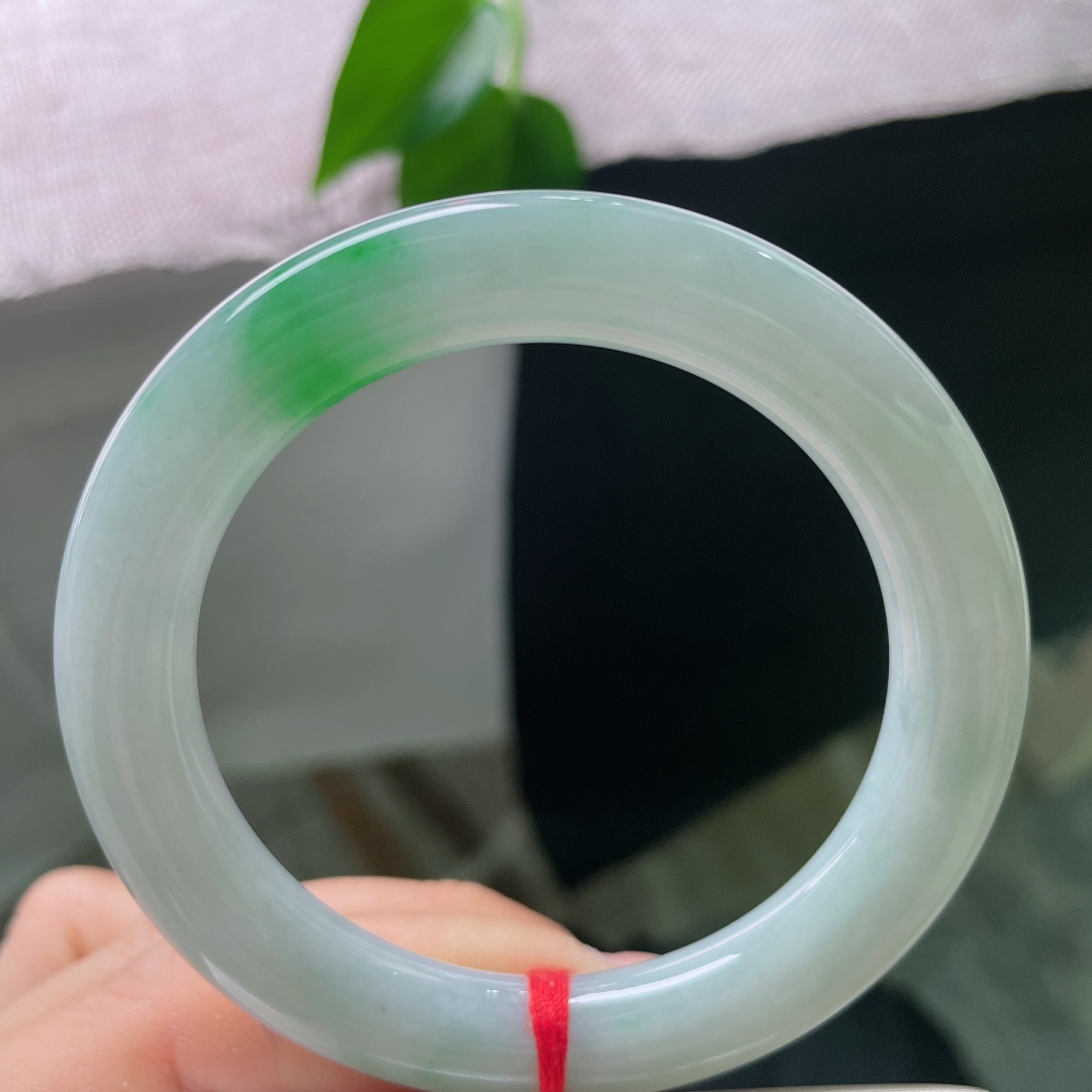 53.1/10，飘绿圆条，一点皮纹，一抹鲜翠悄然落于镯身，翠色灵动鲜活，如春风拂过山间碧潭，清逸温婉