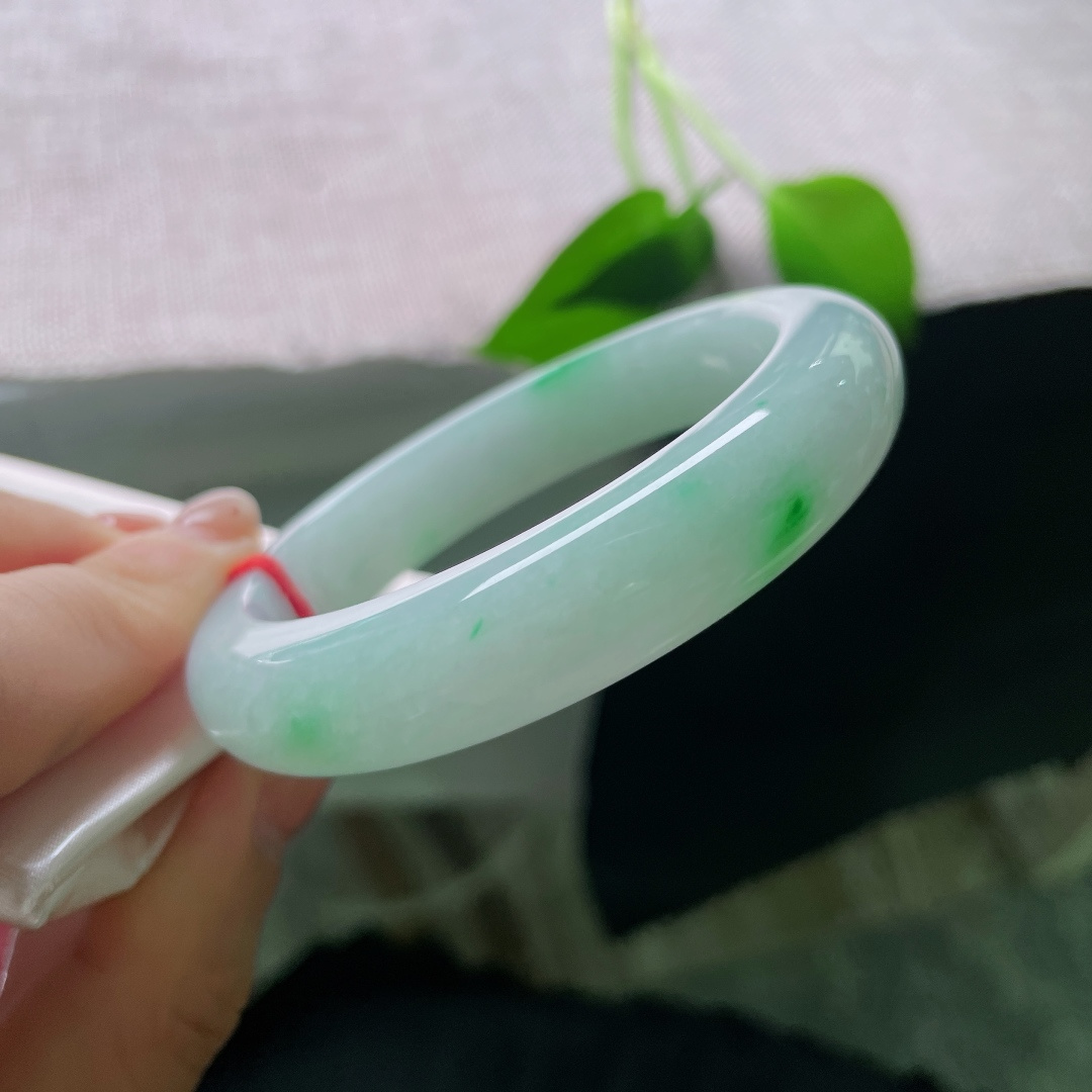 55.3/12.6/9.1，飘绿正圈，一点皮纹，玉质通透莹润，底色柔和淡雅，星星点点正阳绿点缀其间，不浓不艳，点点翠光，灵动又别致。ss56719a