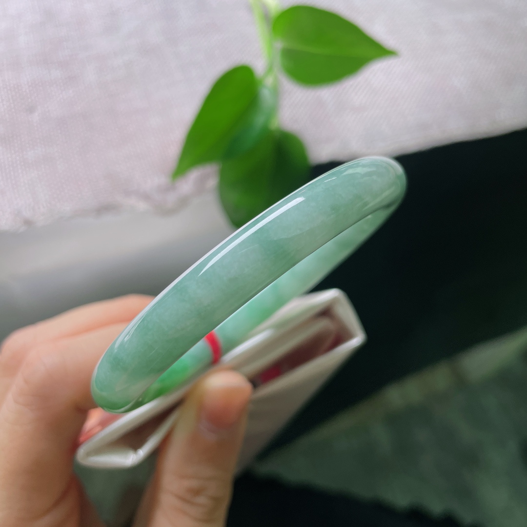 55.4/9.2，飘绿圆条，一点内纹，圆条镯型敦实雅致，绿水氤氲镯身，水光内敛，把一池远山碧色，戴于方寸腕间。ss56930a