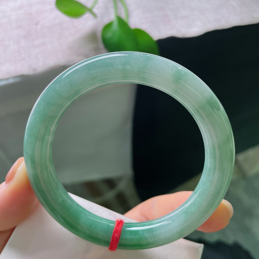 55.7/10.1，飘绿圆条，一点内纹，玉质莹润通透，色泽由浅至深缓缓晕染，自带沉静温润的氛围感，含蓄又大气。ss56925a