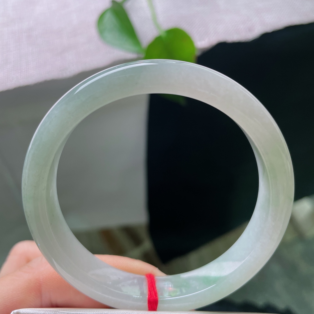 57/10.9/6.7，绿底正圈，一点晶体，浅晴底色翡翠镯，玉质细腻水润，色调温润耐看，日常通勤百搭，不挑肤色。ss56962a