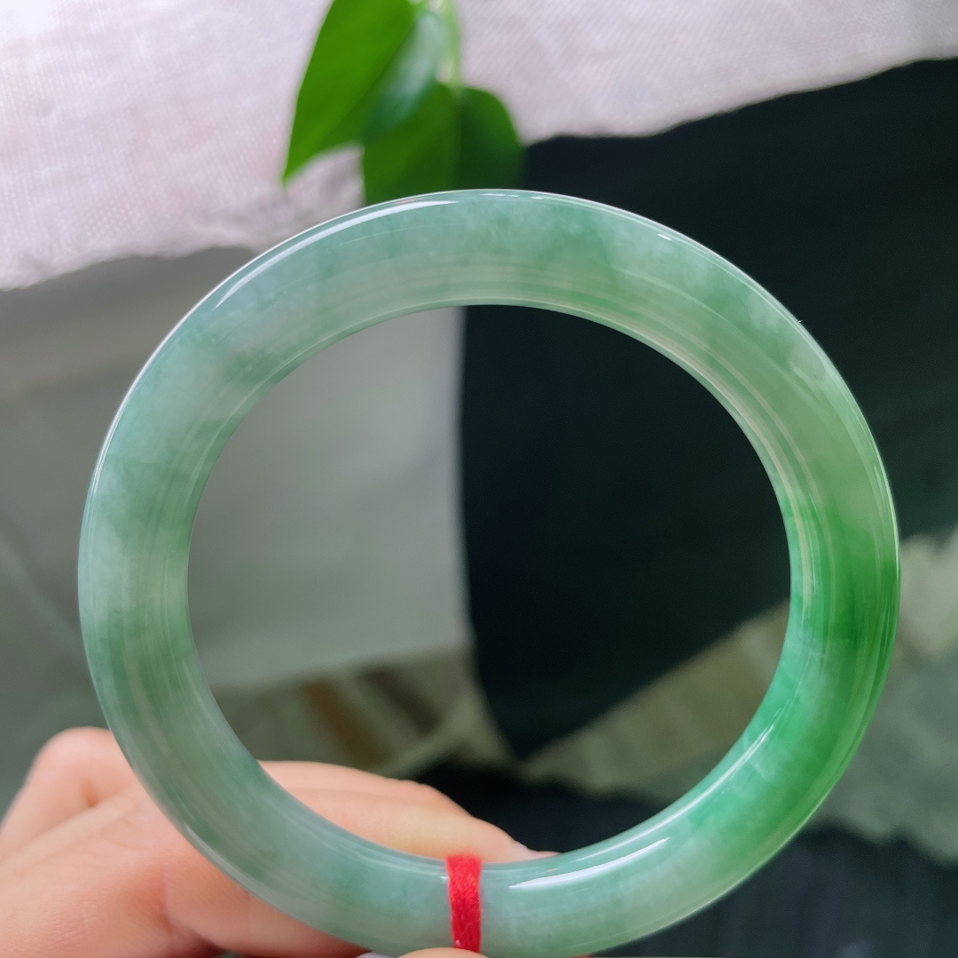 55.4/9.2，飘绿圆条，一点内纹，圆条镯型敦实雅致，绿水氤氲镯身，水光内敛，把一池远山碧色，戴于方寸腕间。ss56930a