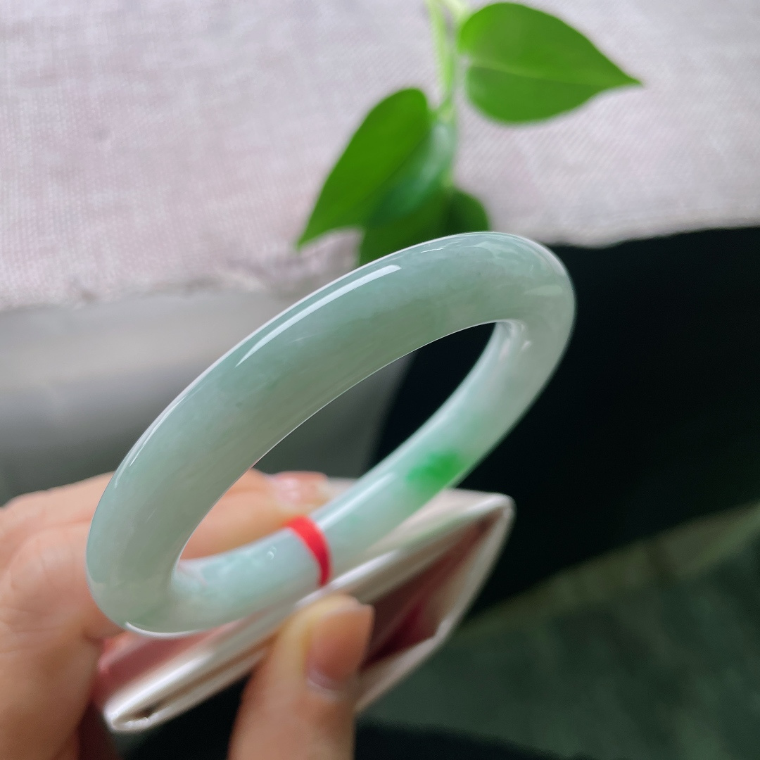 53.1/10，飘绿圆条，一点皮纹，一抹鲜翠悄然落于镯身，翠色灵动鲜活，如春风拂过山间碧潭，清逸温婉。ss56713a