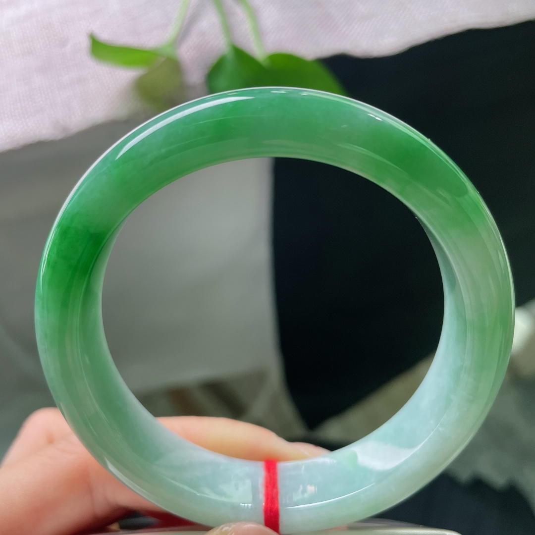 58.7/14.2/8.8，飘绿正圈，无裂，正阳翠色落于镯身，绿艳鲜活，由浓翠缓缓晕向浅青，恰似两岸