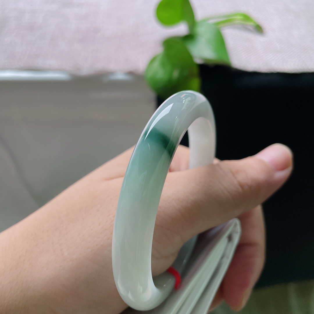 53.9/9.2/7.9，飘花正圈，无裂，底子通透干净，一侧聚敛浓郁深绿飘花，色彩对比鲜明，纤细镯身轻盈秀气，上手精致小巧。ss57123a