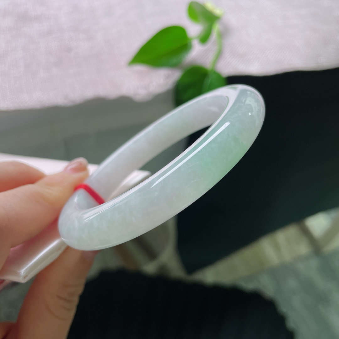 58.5/10.8/9.6，飘绿正圈，无裂，色泽低调温柔，镯身晕染着一抹清新嫩绿，似春日浅苔藏于素白雪底，举手投足间流露雅致质感。ss56750a