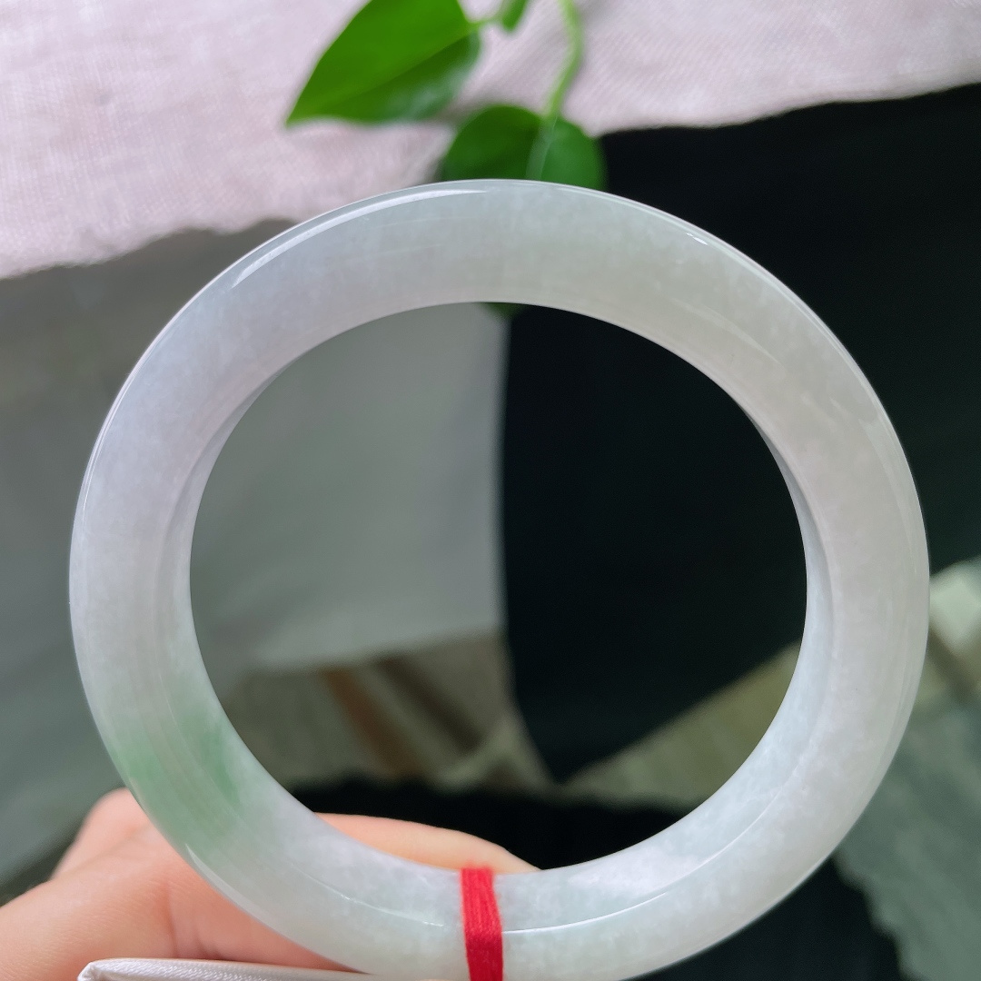 58.5/10.8/9.6，飘绿正圈，无裂，色泽低调温柔，镯身晕染着一抹清新嫩绿，似春日浅苔藏于素白雪底，举手投足间流露雅致质感。ss56750a