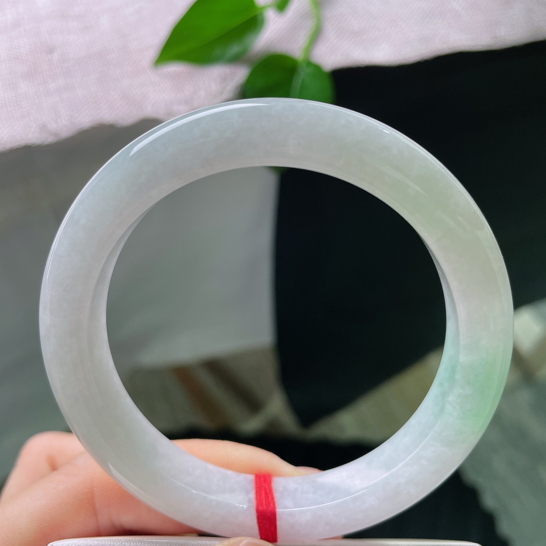 58.5/10.8/9.6，飘绿正圈，无裂，色泽低调温柔，镯身晕染着一抹清新嫩绿，似春日浅苔藏于素白雪底，举手投足间流露雅致质感。ss56750a
