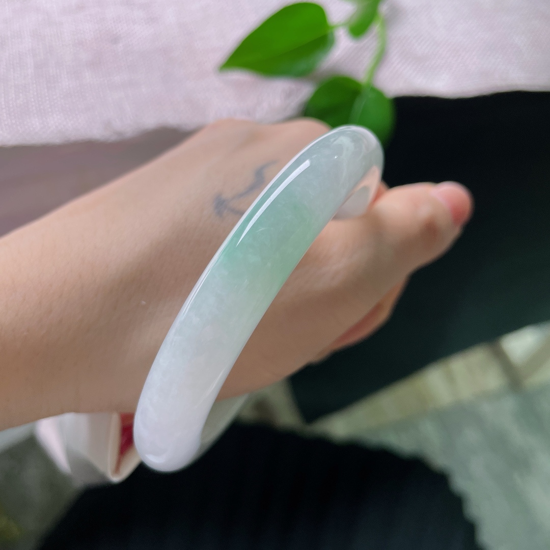 58.5/10.8/9.6，飘绿正圈，无裂，色泽低调温柔，镯身晕染着一抹清新嫩绿，似春日浅苔藏于素白雪底，举手投足间流露雅致质感。ss56750a