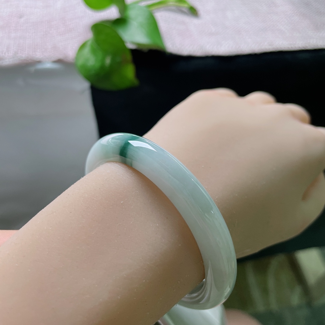 53.9/9.2/7.9，飘花正圈，无裂，底子通透干净，一侧聚敛浓郁深绿飘花，色彩对比鲜明，纤细镯身轻盈秀气，上手精致小巧。ss57123a