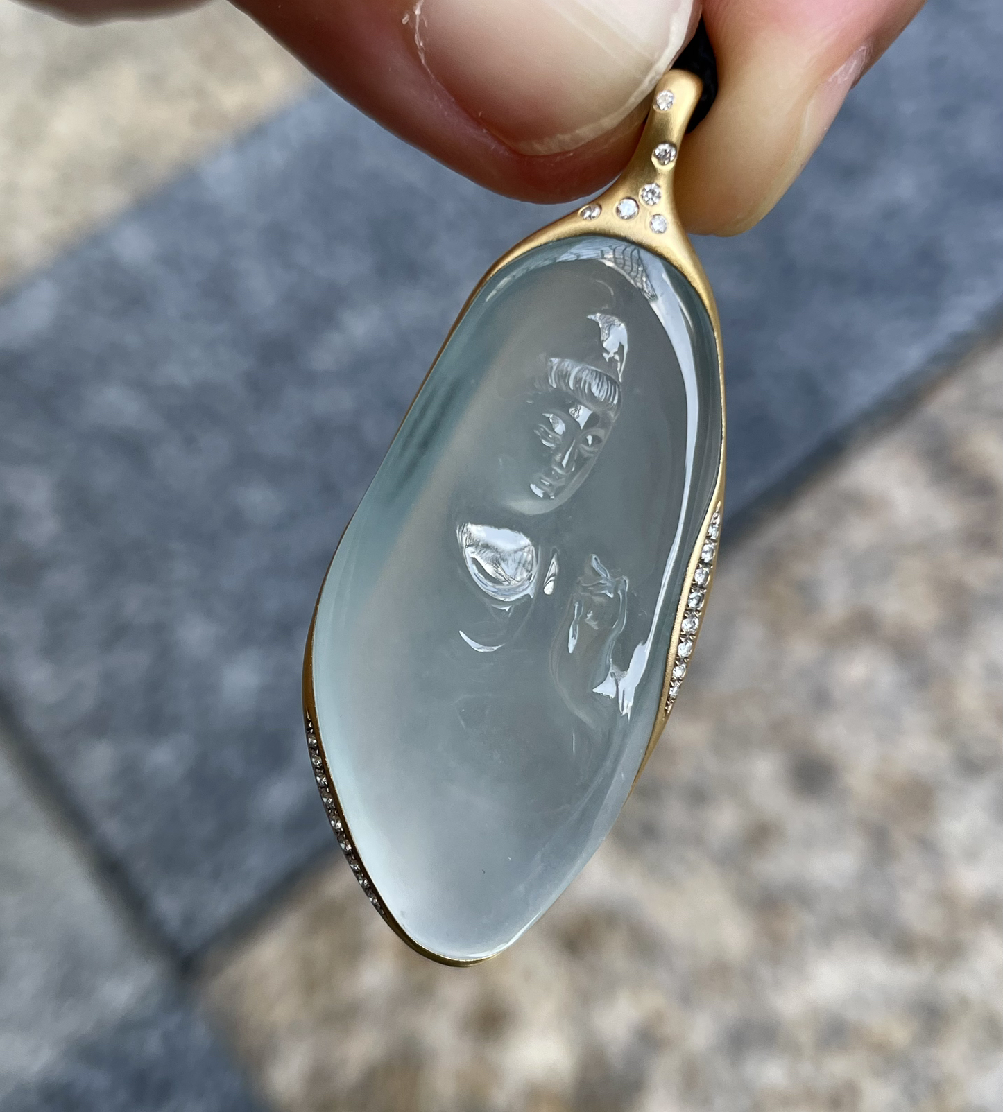 【冰种观音首吊坠】侧面像，料子通透闪亮，质地致密，种老起强胶感，人物面部开脸生动，雕刻很精细，表情端庄祥和。料子纯净，18K金钻镶嵌，裸石尺寸36.8*18.3*6.3毫米