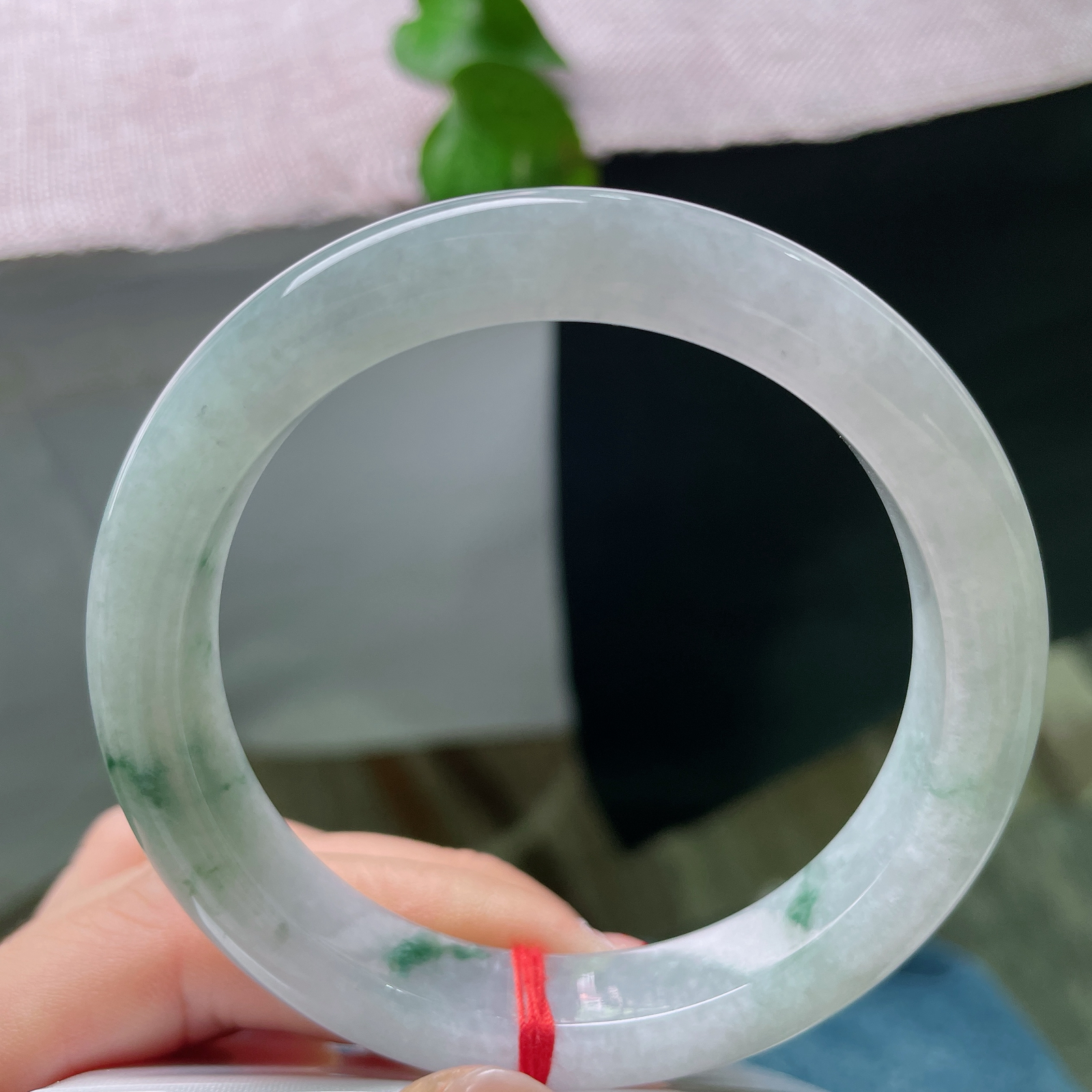 57.7/11.2/9.2，飘花正圈冰底凝翠，柔光漫过素玉圆镯，零星绿丝随性晕开，将一池清潭绿意收于腕间ss57532a