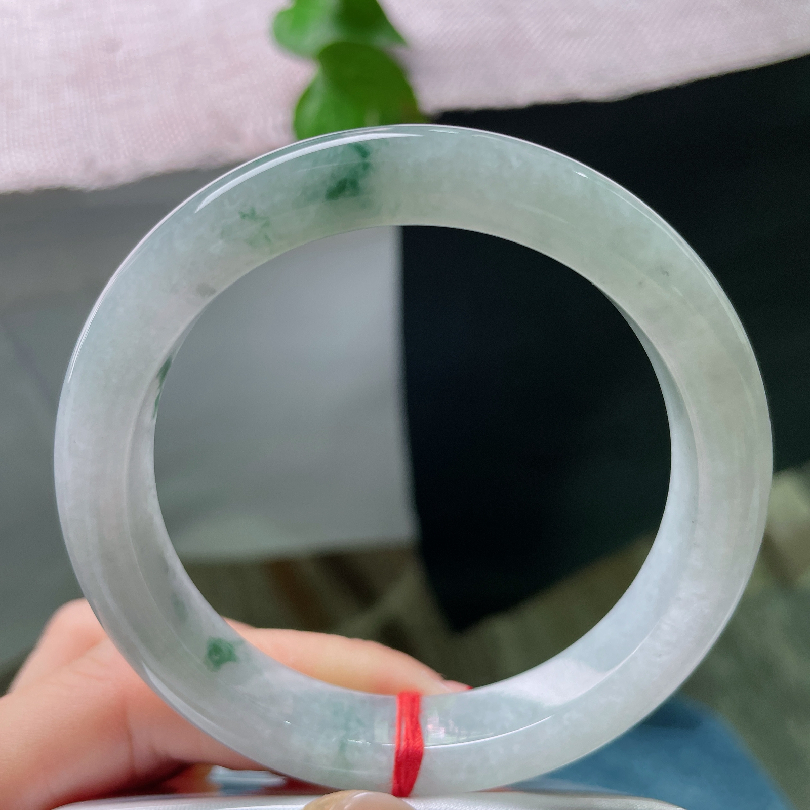 57.7/11.2/9.2，飘花正圈冰底凝翠，柔光漫过素玉圆镯，零星绿丝随性晕开，将一池清潭绿意收于