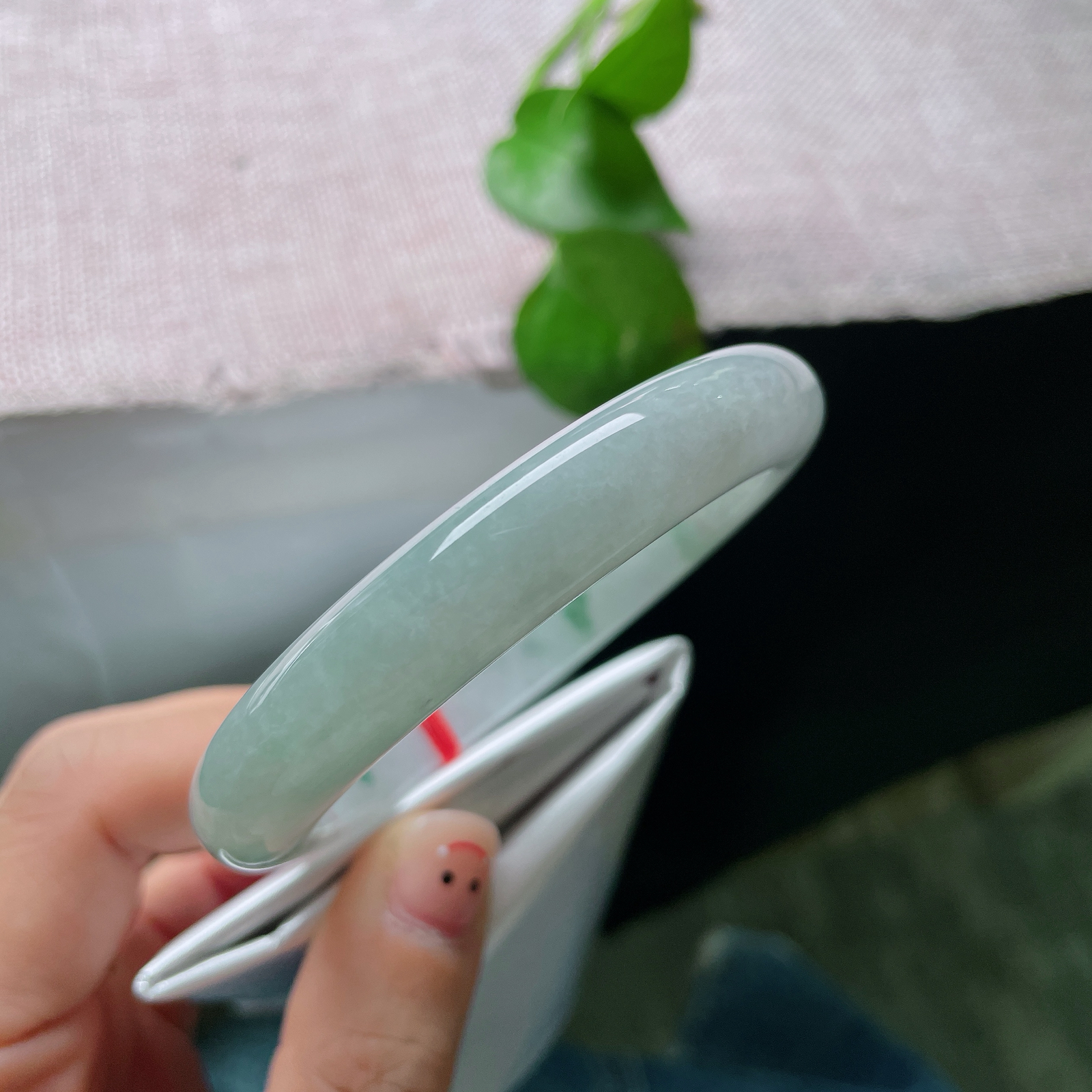 57.7/11.2/9.2，飘花正圈冰底凝翠，柔光漫过素玉圆镯，零星绿丝随性晕开，将一池清潭绿意收于腕间ss57532a