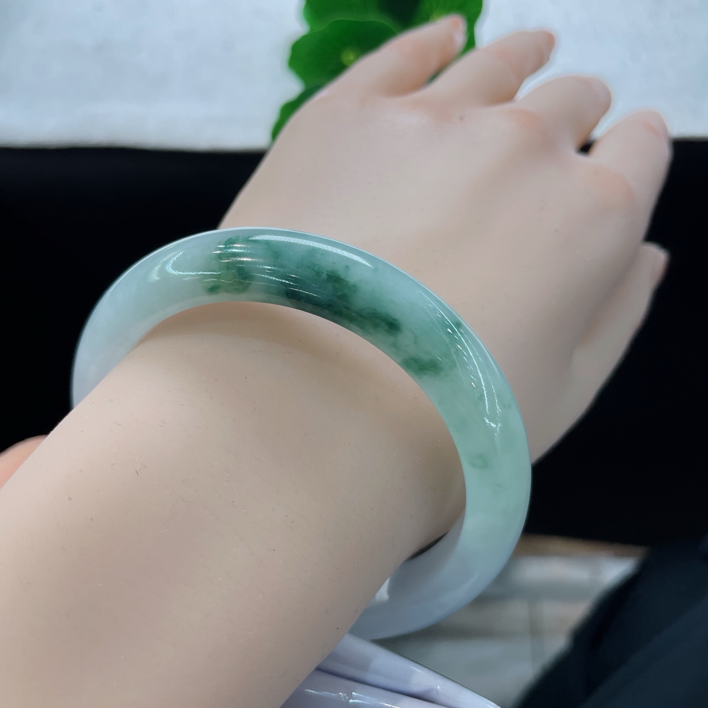 圈口56.9/10.9/8，飘花正圈，脂润莹白基底晕开缥缈墨绿飘花，质地细腻。
