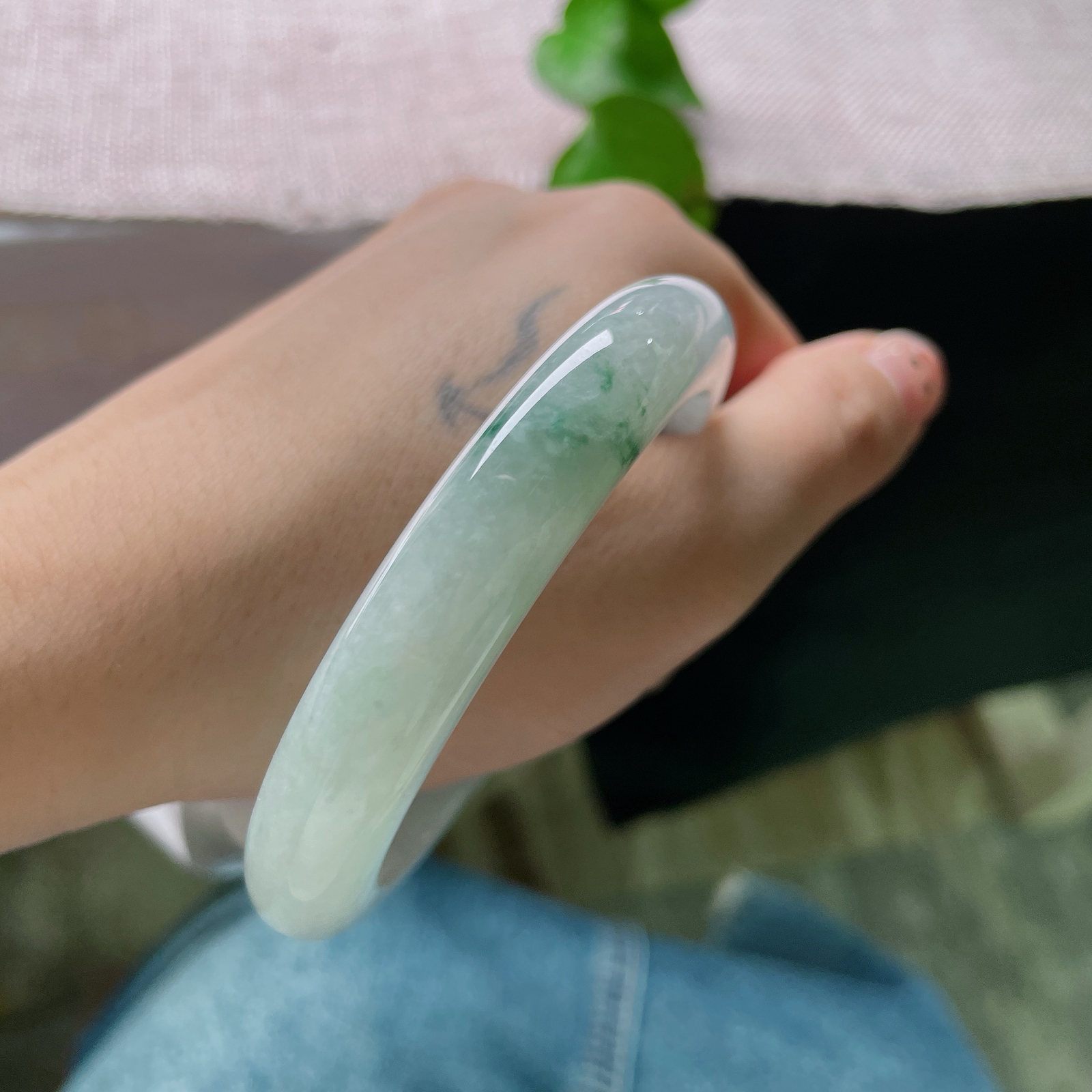 57.7/11.2/9.2，飘花正圈冰底凝翠，柔光漫过素玉圆镯，零星绿丝随性晕开，将一池清潭绿意收于腕间ss57532a