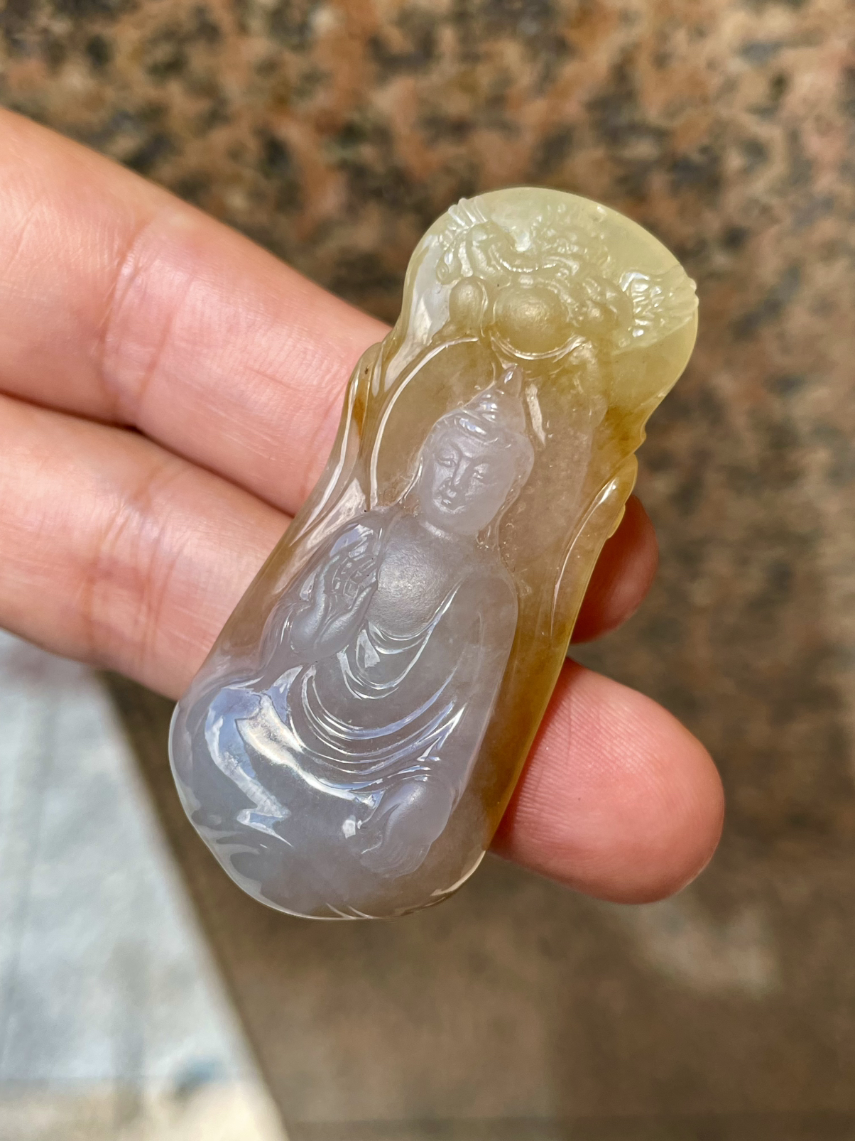 【冰种黄翡御龙观音吊坠】侧面像，料子通透闪亮，质地致密，种老起强胶感，人物面部开脸生动，雕刻很精细，表情端庄祥和。