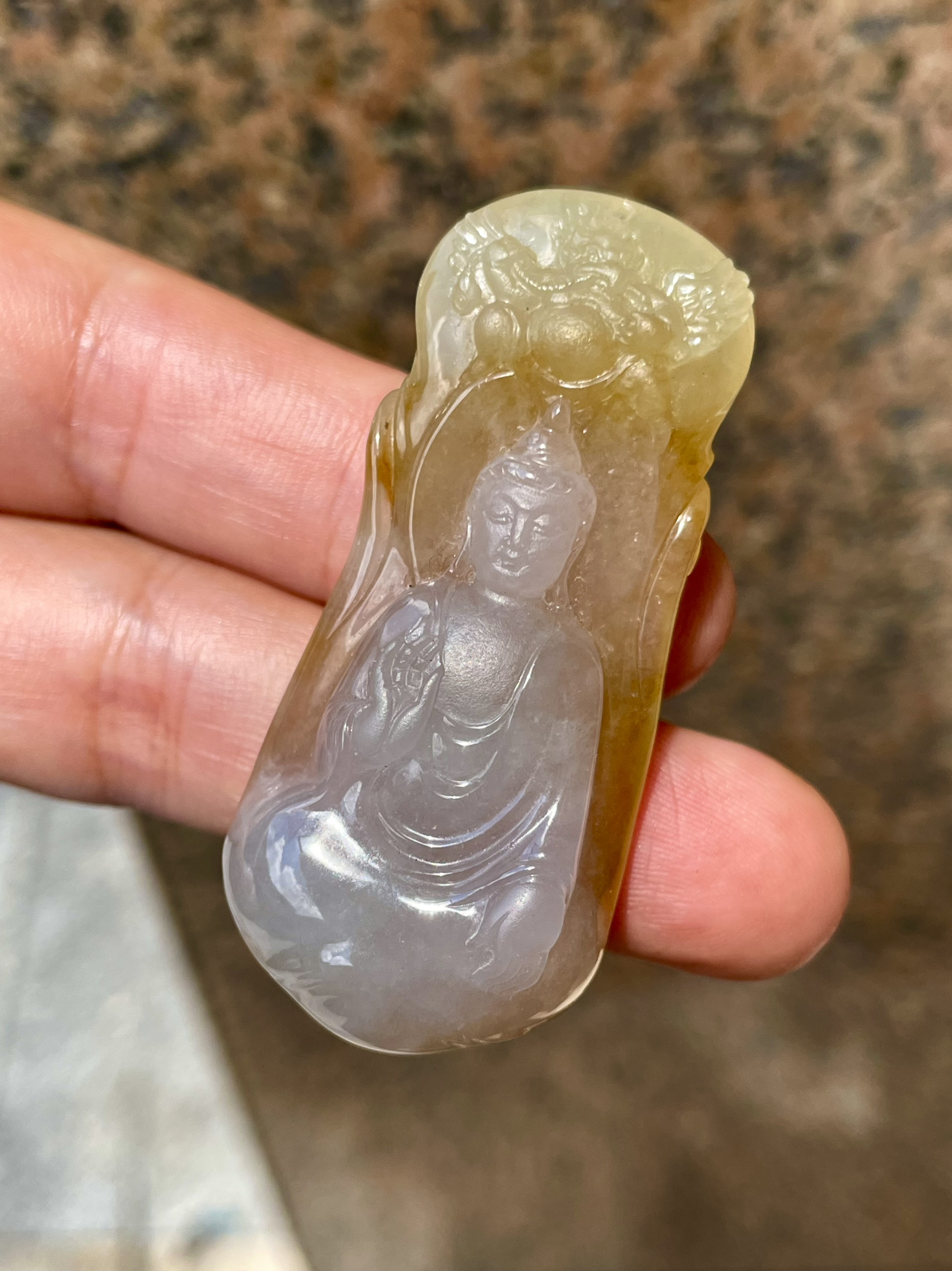 【冰种黄翡御龙观音吊坠】侧面像，料子通透闪亮，质地致密，种老起强胶感，人物面部开脸生动，雕刻很精细，表情端庄祥和。