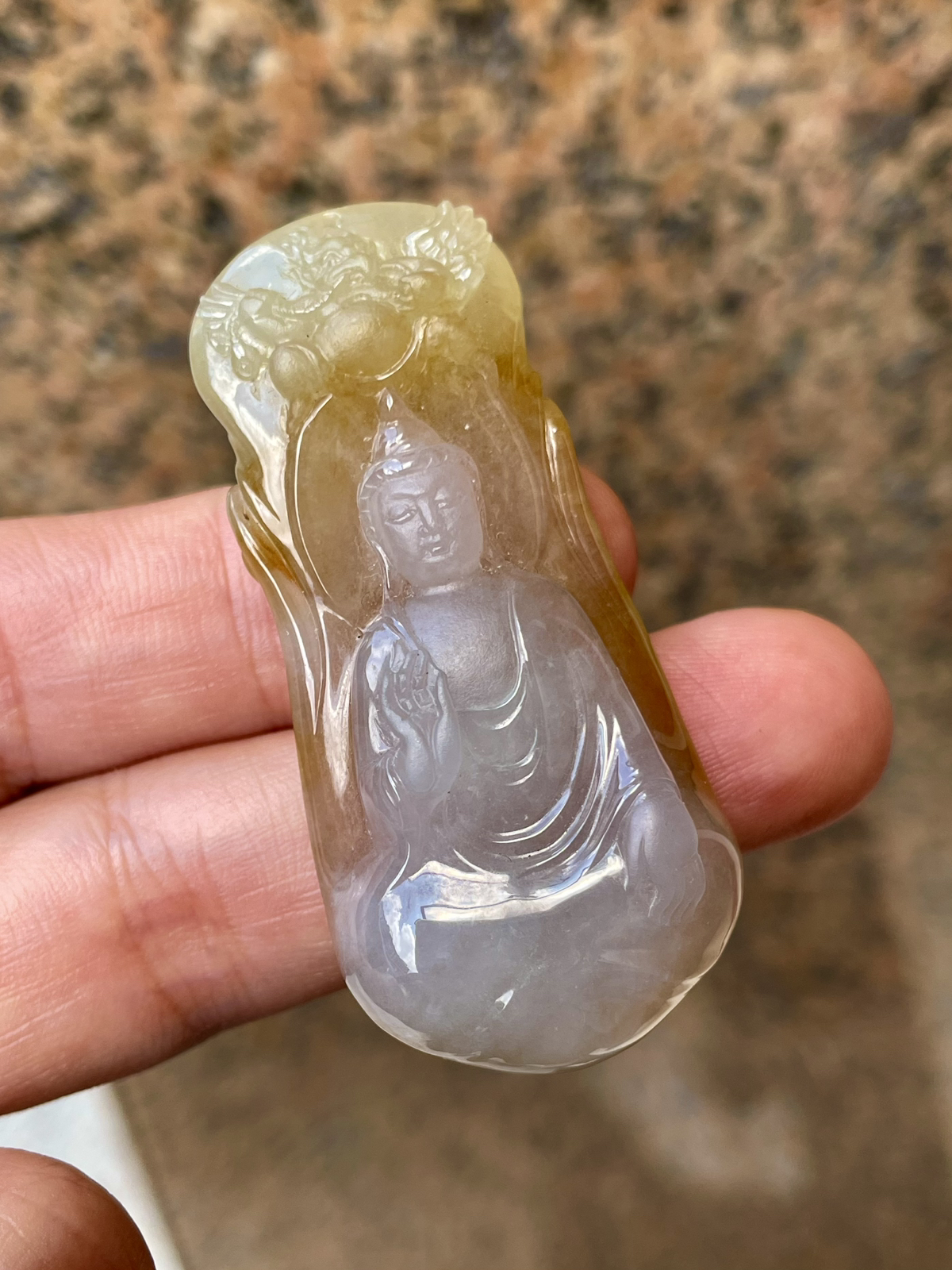 【冰种黄翡御龙观音吊坠】侧面像，料子通透闪亮，质地致密，种老起强胶感，人物面部开脸生动，雕刻很精细，表情端庄祥和。