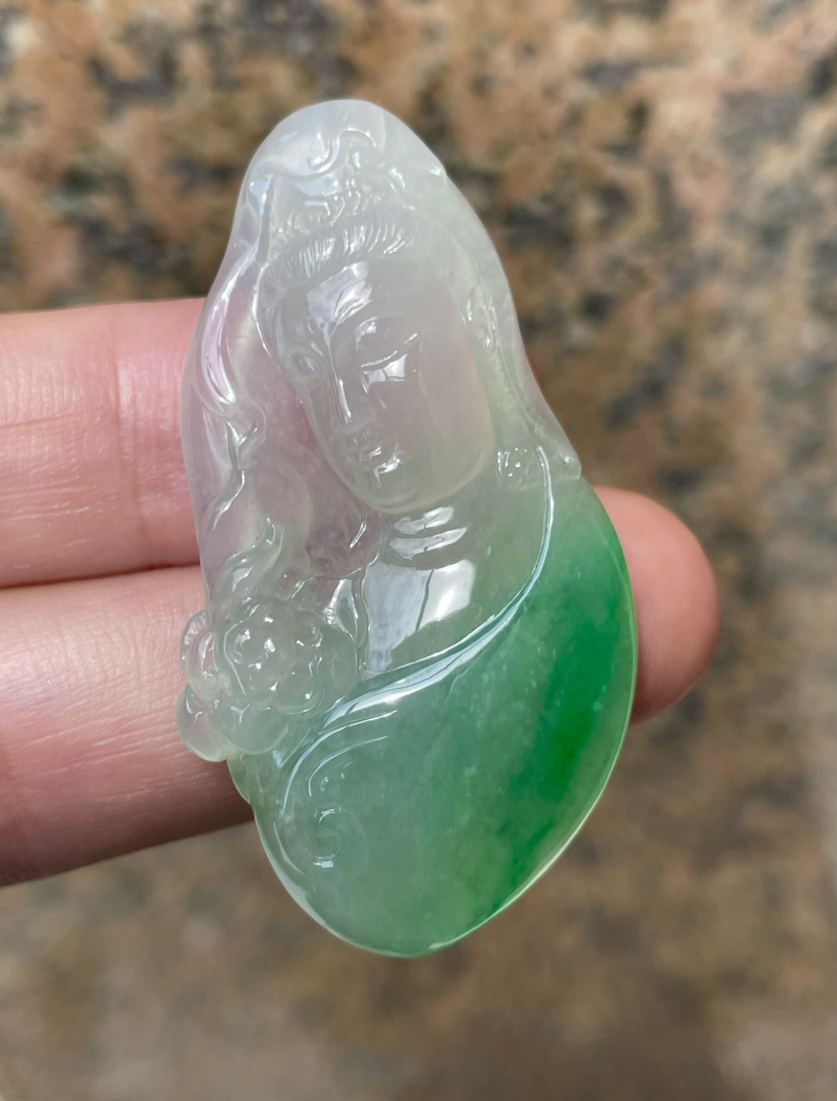 【冰种飘绿观音首吊坠】侧面像，料子通透闪亮，质地致密，种老起强胶感，人物面部开脸生动，雕刻很精细，表情端庄祥和。