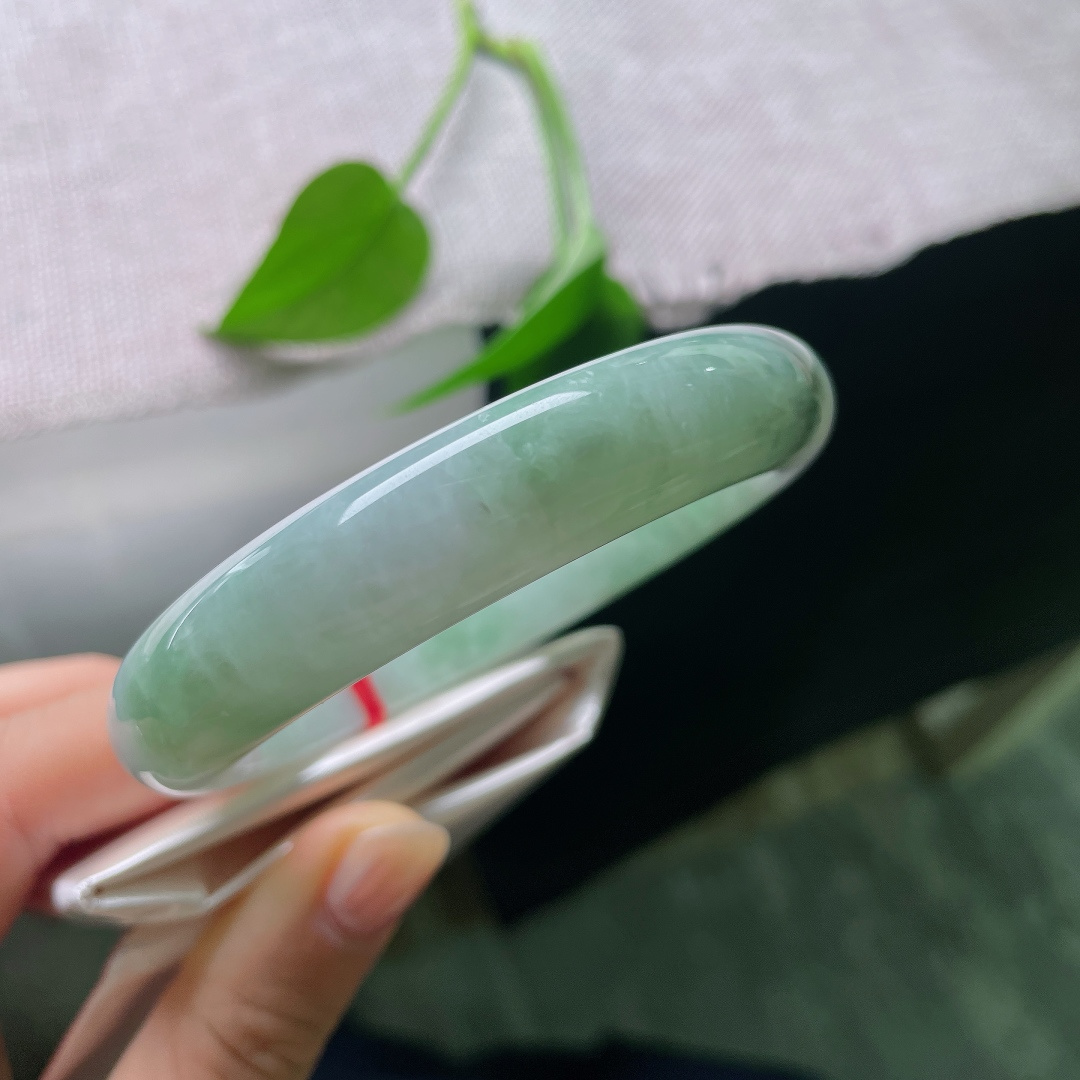 飘花正圈，有裂，玉质细腻，翠色点缀鲜活灵动，端庄中透着一抹亮眼生机。ss57844a