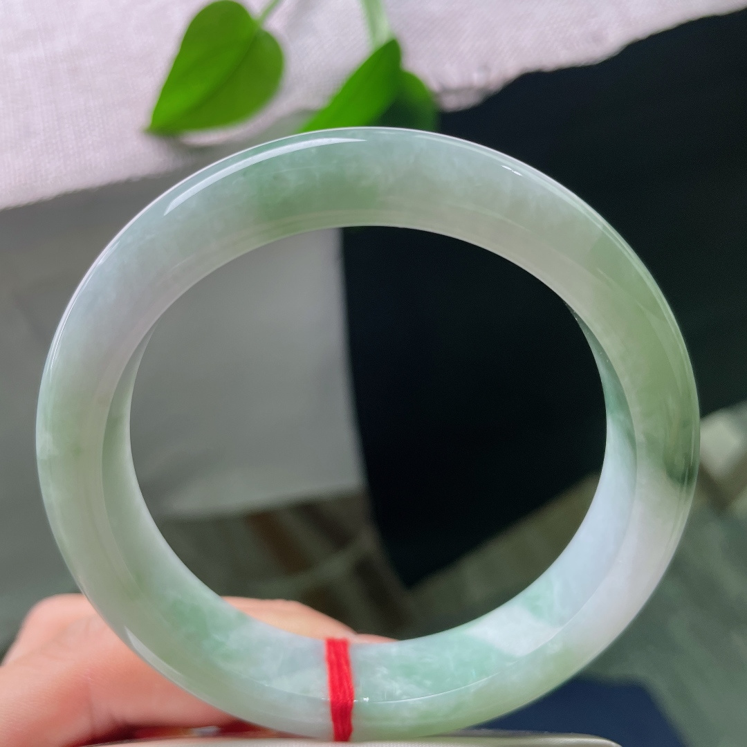 飘花正圈，有裂，玉质细腻，翠色点缀鲜活灵动，端庄中透着一抹亮眼生机。ss57844a