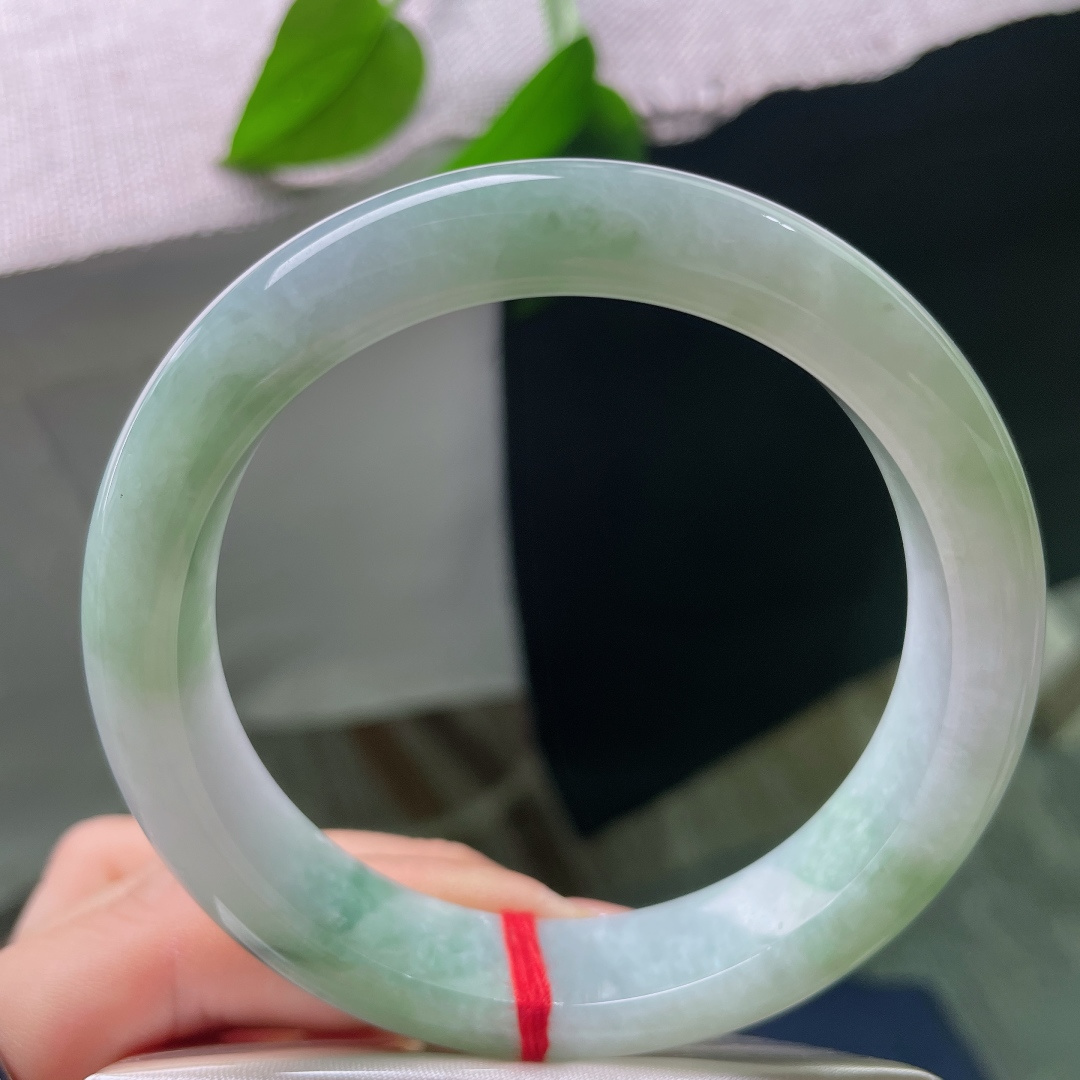 飘花正圈，有裂，玉质细腻，翠色点缀鲜活灵动，端庄中透着一抹亮眼生机。ss57844a