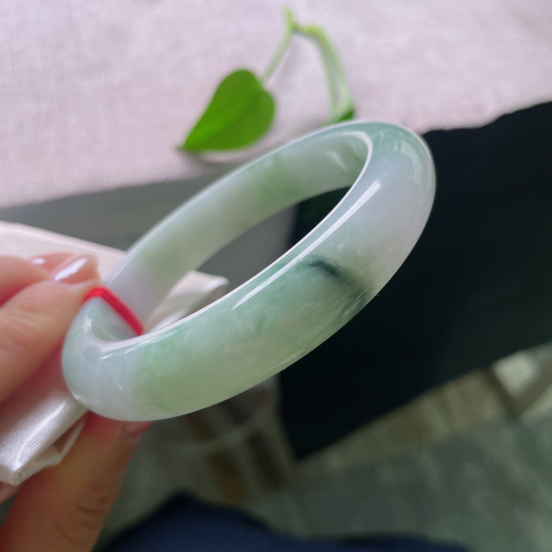 飘花正圈，有裂，玉质细腻，翠色点缀鲜活灵动，端庄中透着一抹亮眼生机。ss57844a