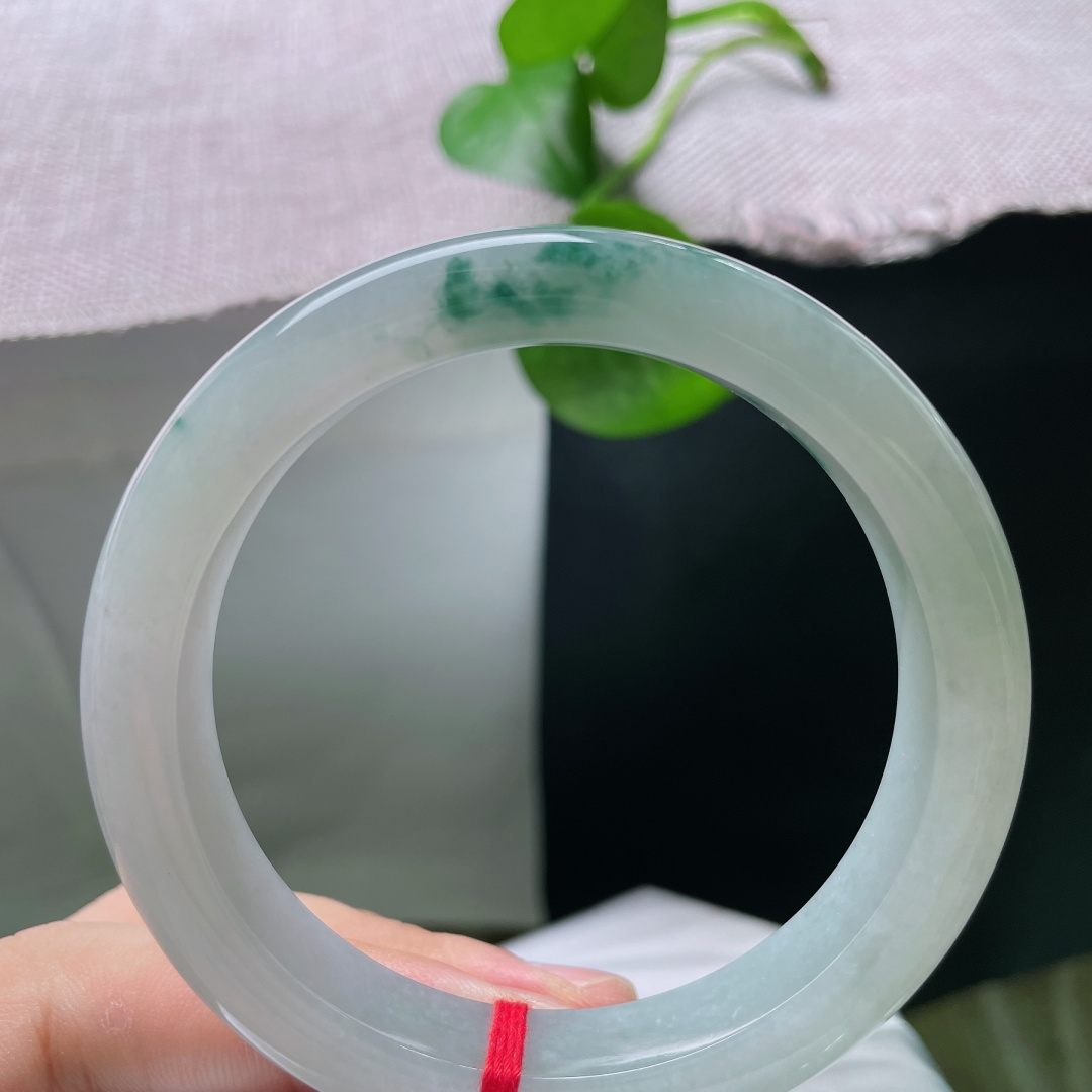 飘花正圈，底色清透白净，点缀一丛浓绿飘花，花色灵动集中，玉质通透带柔和胶感，素雅底色衬得一抹翠色格外