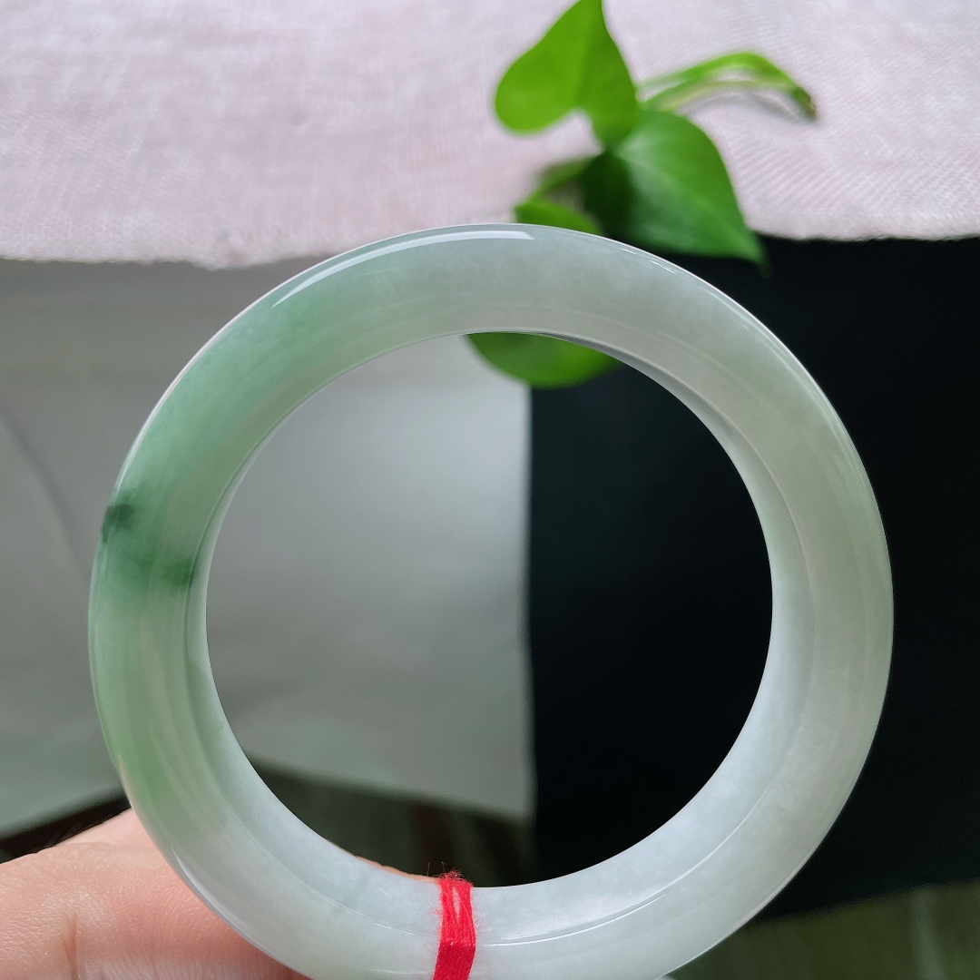 飘花正圈，有纹，玉质温润细腻，一侧凝聚浓郁深绿飘花，浓绿与白底相互映衬，复古韵味十足。ss55799a