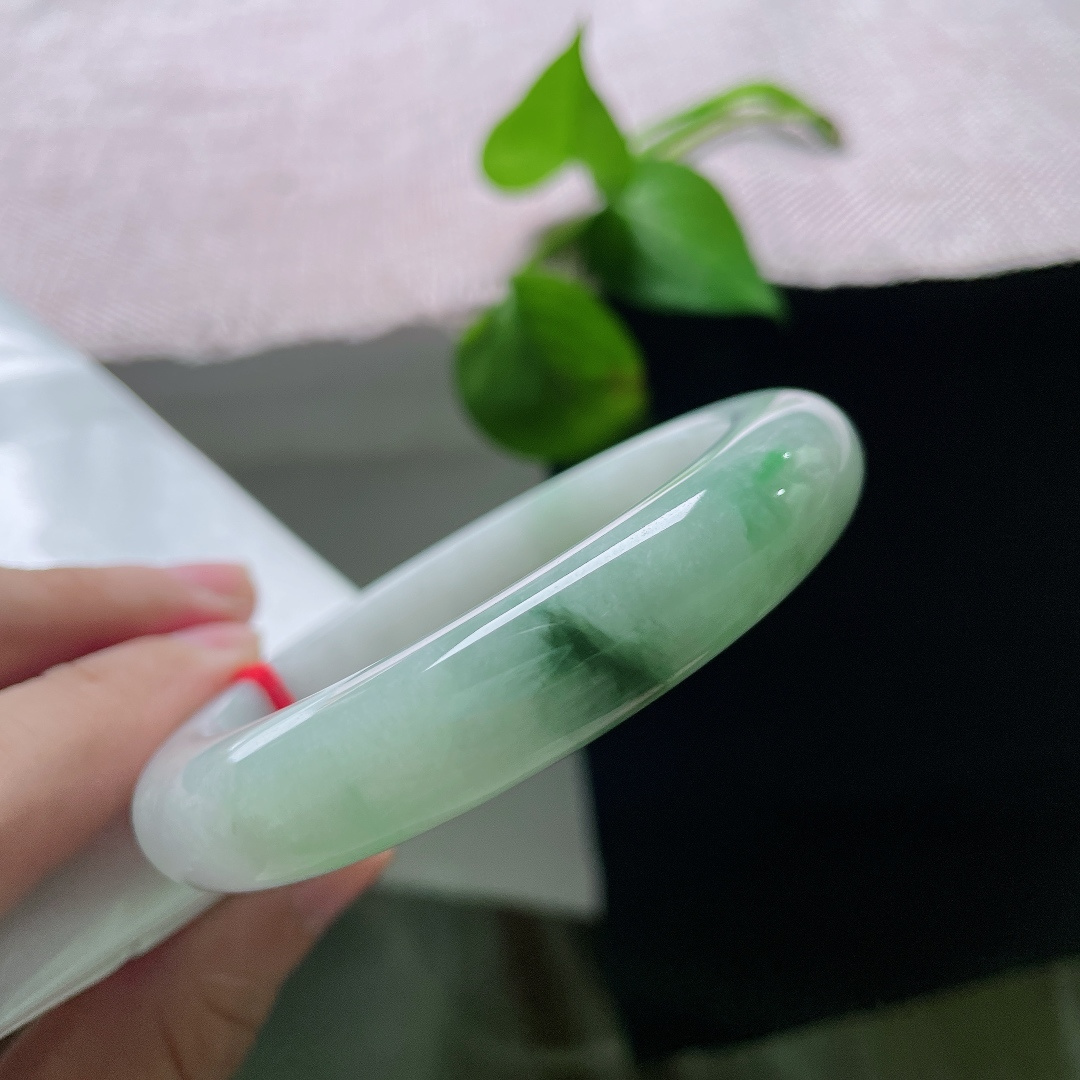 飘花正圈，有纹，玉质温润细腻，一侧凝聚浓郁深绿飘花，浓绿与白底相互映衬，复古韵味十足。ss55799a