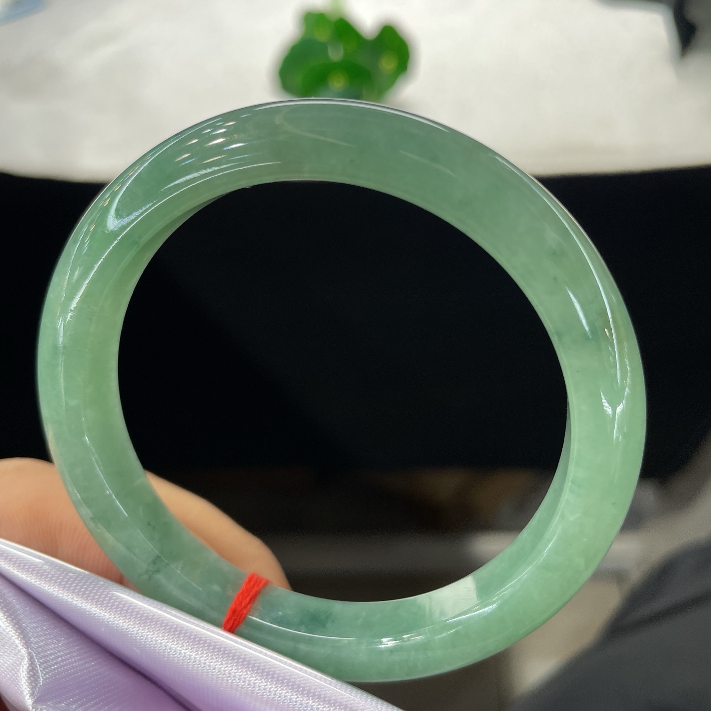 圈口58.6/10.2/8.2，果绿正圈，58/59可戴，仿若碧涧含烟，质地温润澄澈。清润湖绿。无裂。