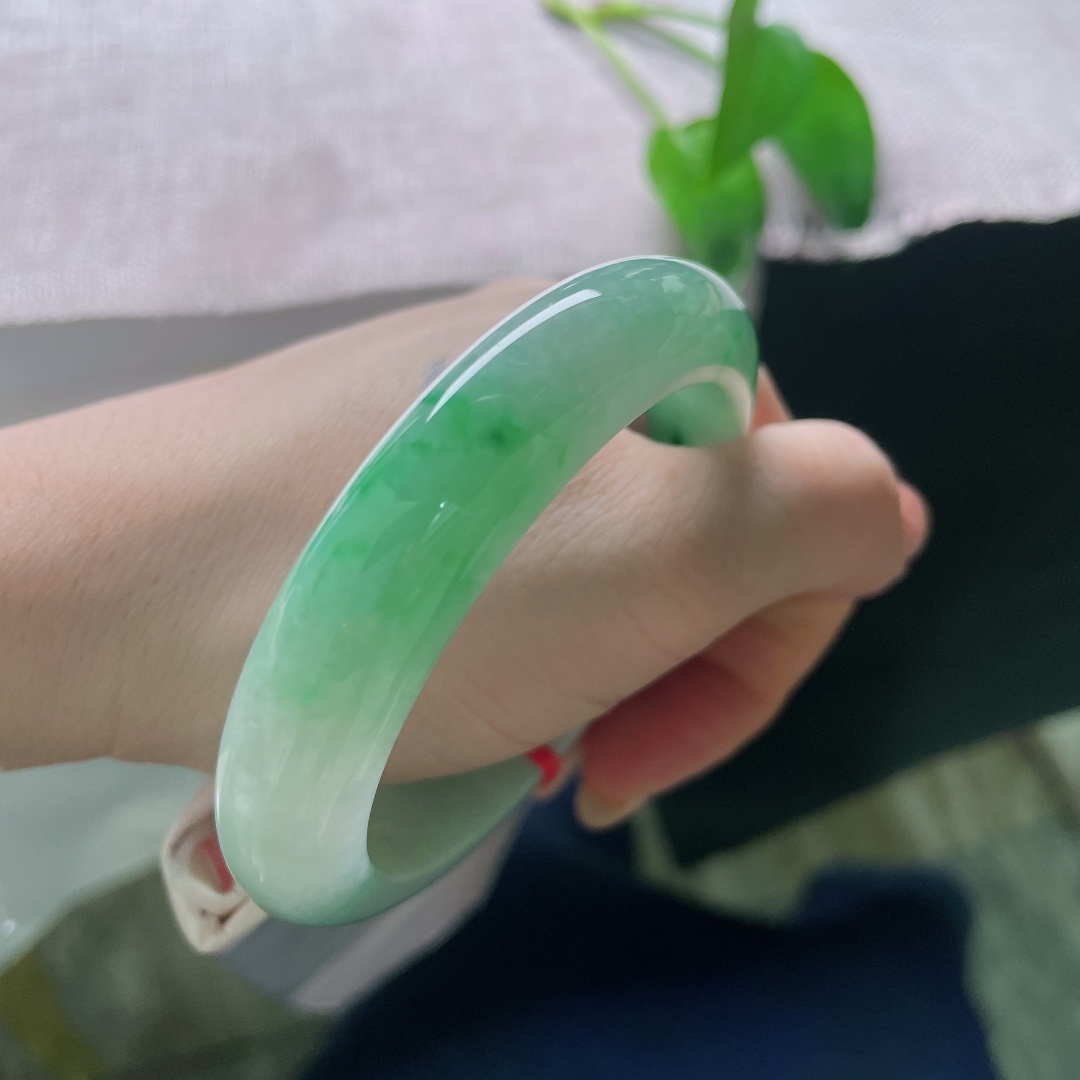 飘绿正圈，无裂，飘花自然写意，如同青山拂过薄雾，片片翠意流淌于玉镯之间，充满诗情画意。ss57974a