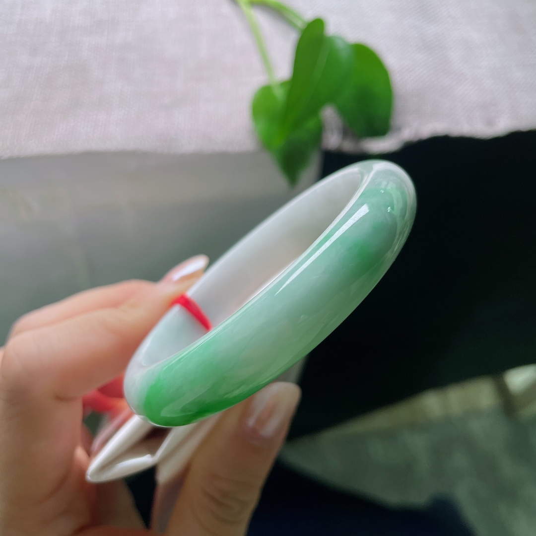 白底青正圈，一点皮纹，玉质细腻柔和，一截鲜亮辣绿缓缓铺展，上手清雅明媚，尽显温婉的中式韵味。ss57996a
