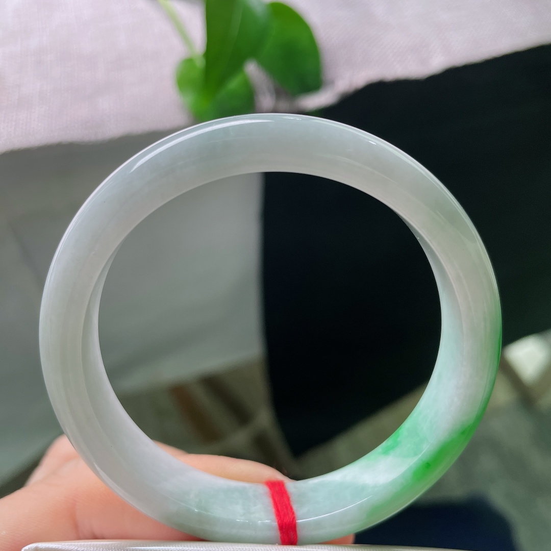 白底青正圈，一点皮纹，玉质细腻柔和，一截鲜亮辣绿缓缓铺展，上手清雅明媚，尽显温婉的中式韵味。ss57