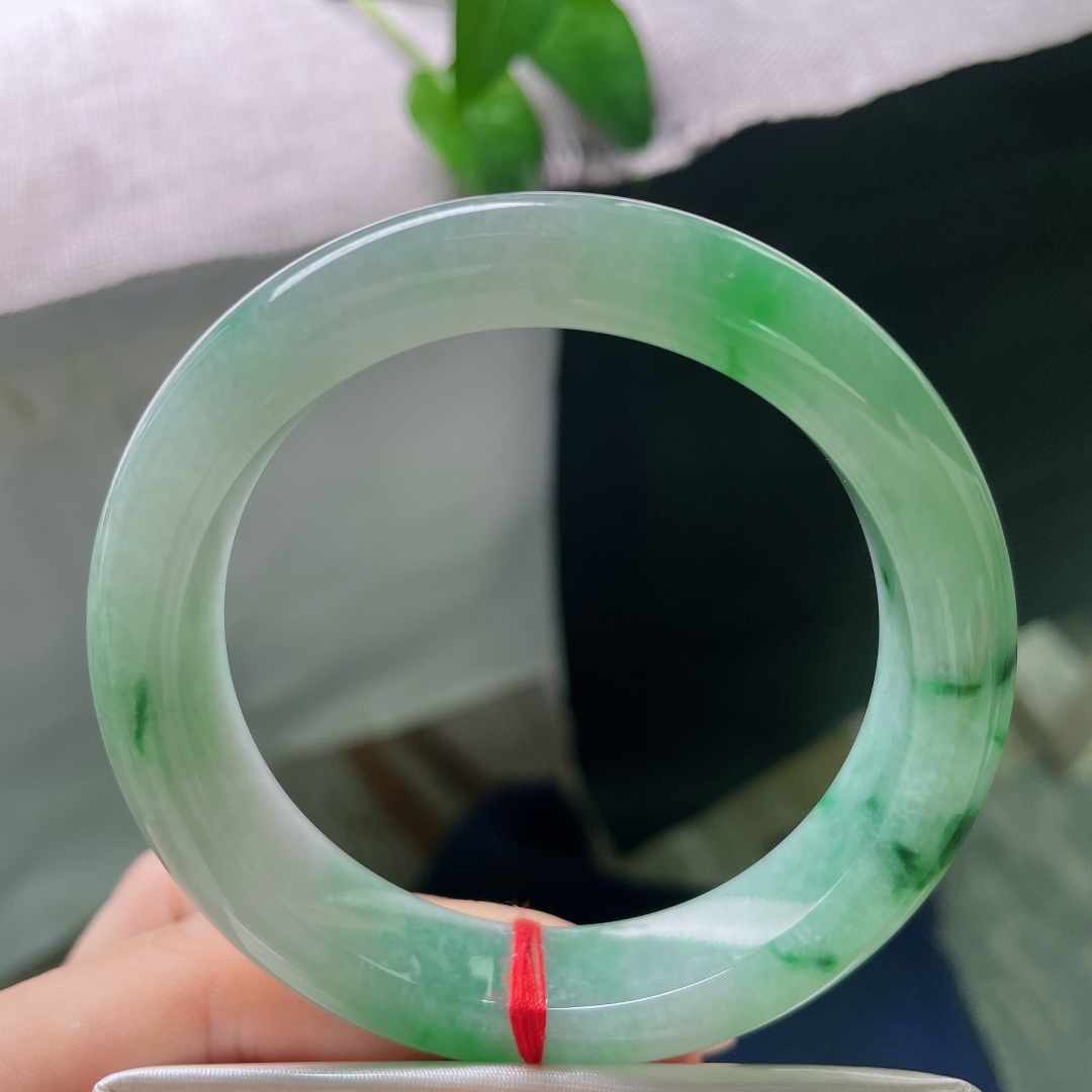 飘绿正圈，无裂，飘花自然写意，如同青山拂过薄雾，片片翠意流淌于玉镯之间，充满诗情画意。ss57974a