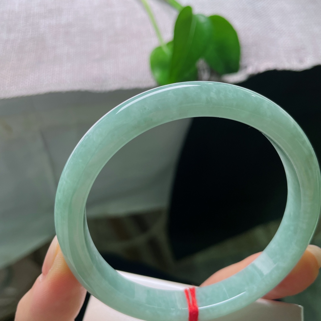 绿底正圈，无裂，镯面光泽温润内敛，不浮不燥，光线漫过镯身，尽显玉石浑厚的底蕴。ss57932a