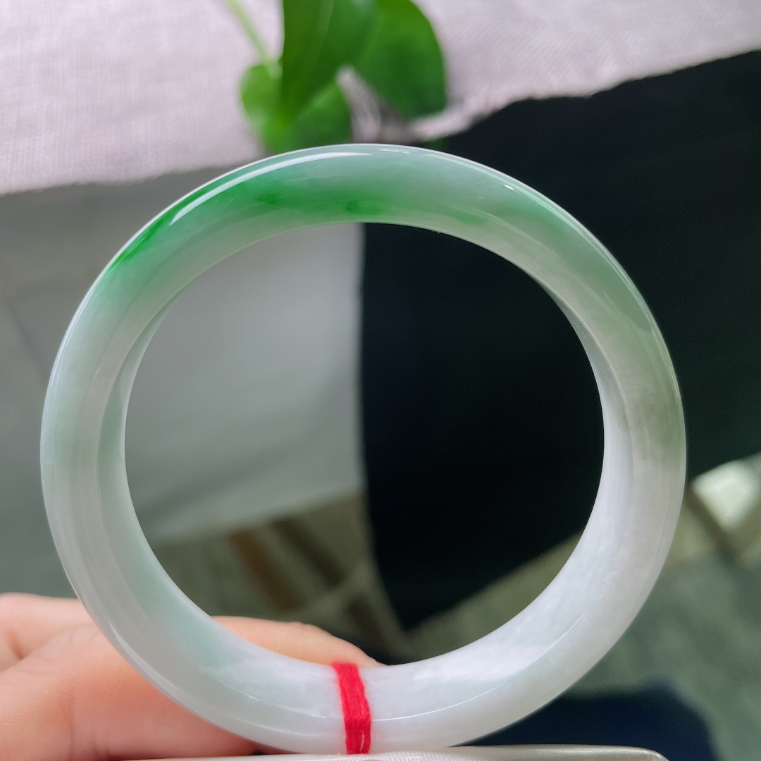 白底青正圈，一点皮纹，玉质细腻柔和，一截鲜亮辣绿缓缓铺展，上手清雅明媚，尽显温婉的中式韵味。ss57