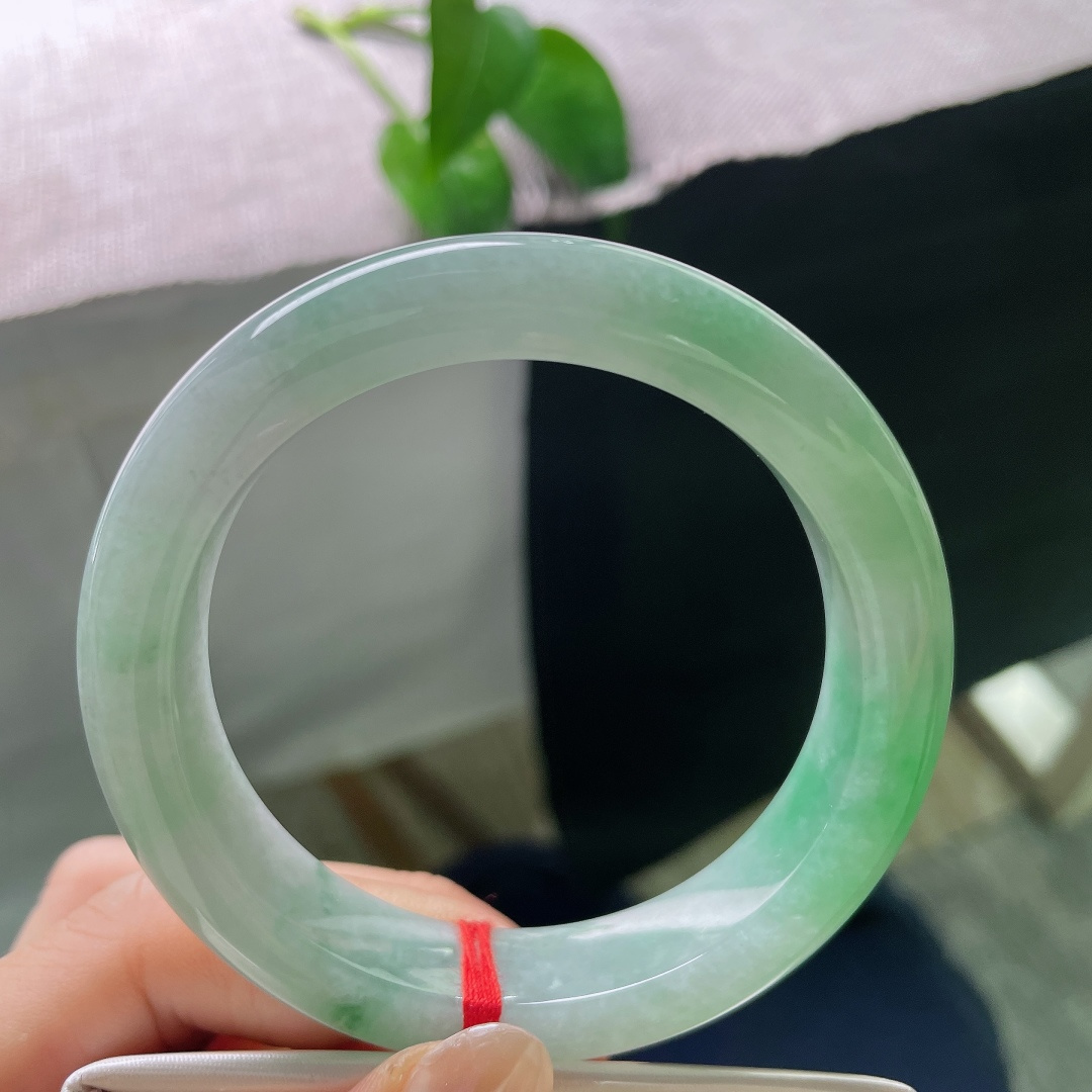 飘绿正圈，无裂，光泽温润清亮，光线掠过镯身，底色清润，绿花灵动，层次感十足。ss57971a
