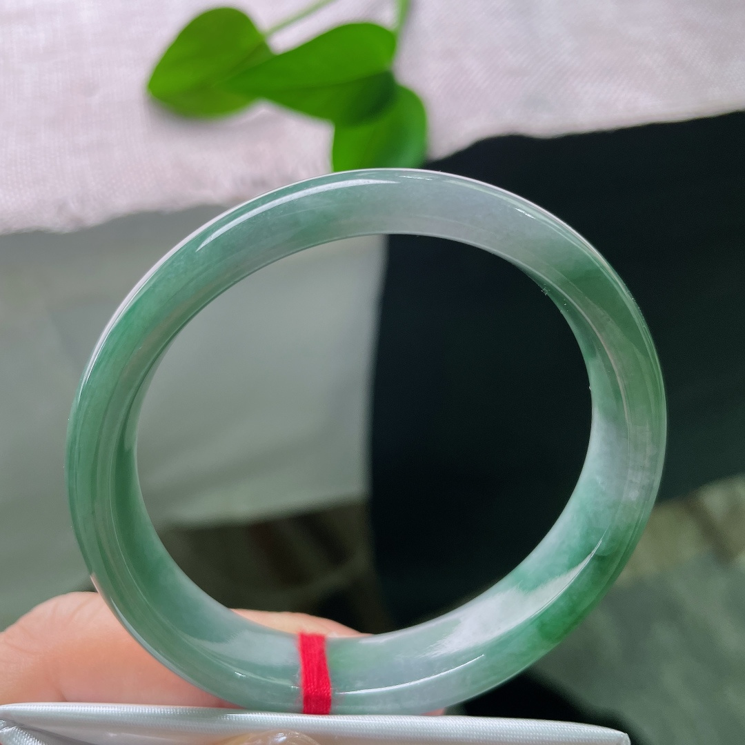 油青贵妃，一点皮纹，冰润飘绿正圈平安镯，半圈是清透的冰种底质，翠色如烟如云，自然飘散于镯身。ss58020a